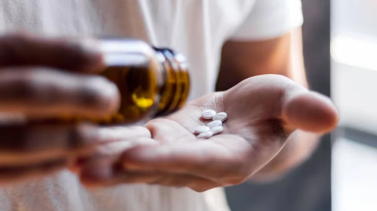 Person holding vitamin c pills in hand showing does vitamin c supplements safe