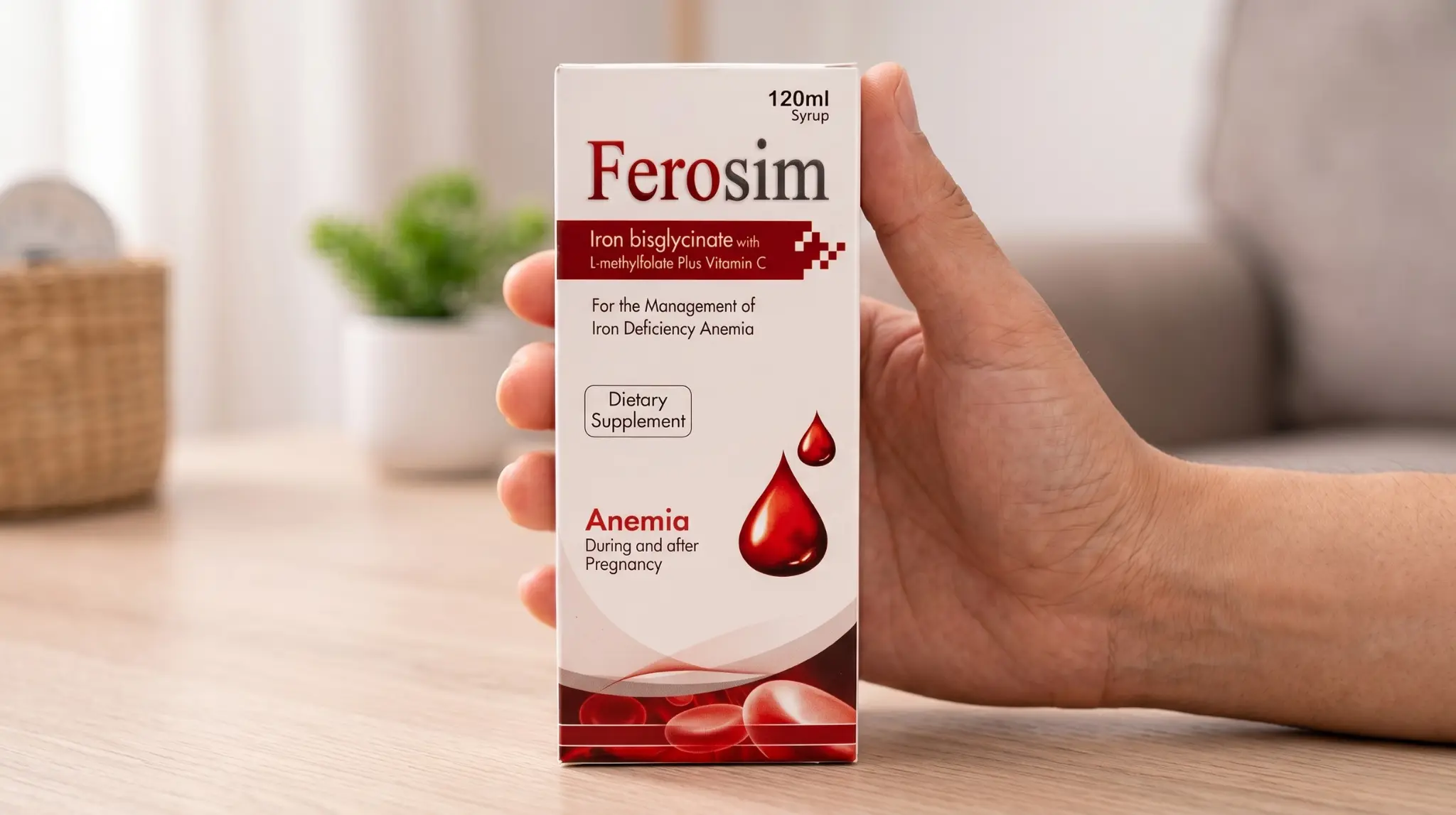 A hand holding a box of Ferosim, a top-rated iron syrup in Pakistan formulated with iron bisglycinate and Vitamin C for hemoglobin support and anemia treatment.