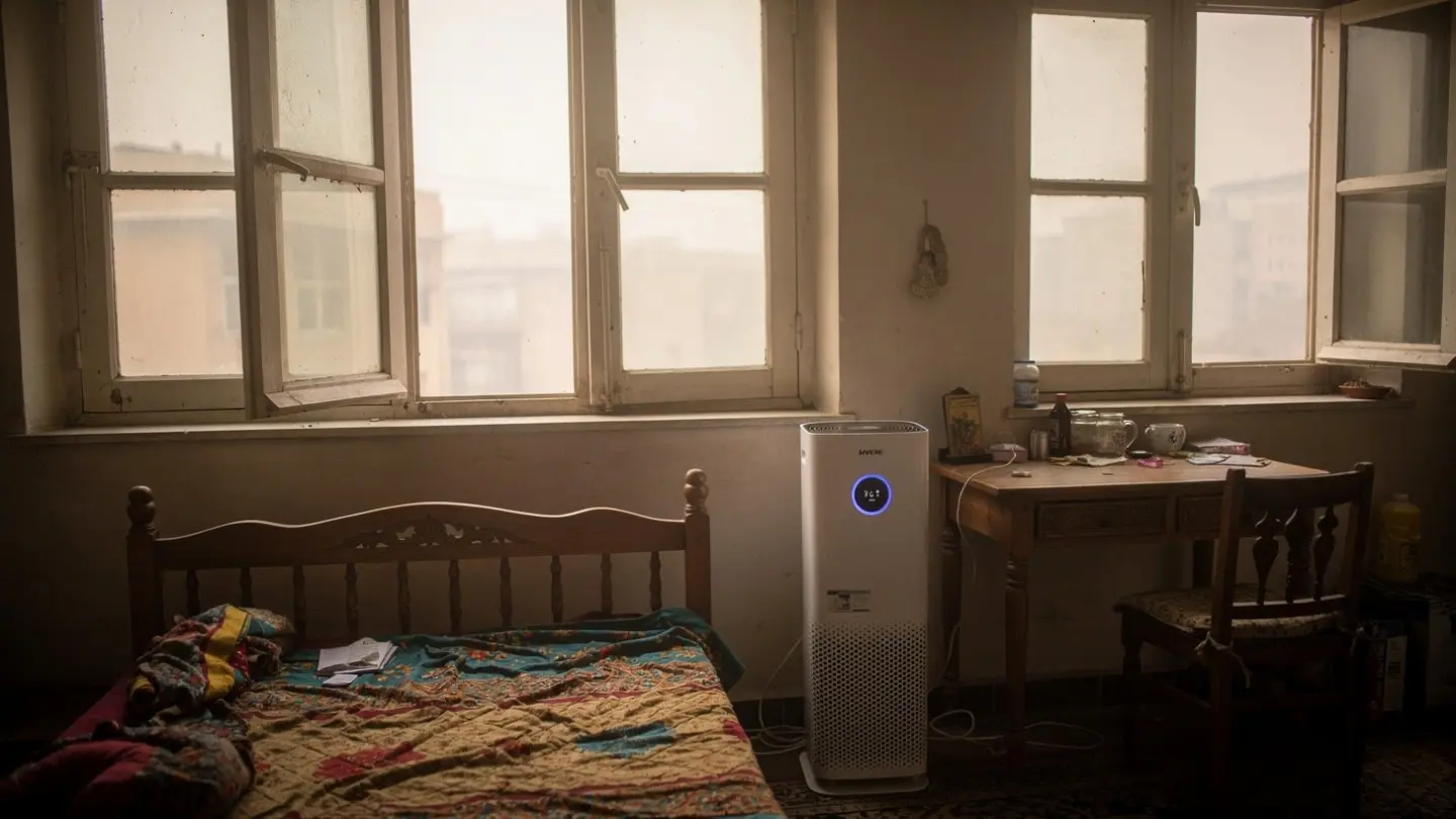 An active air purifier placed inside a traditional room next to a window, helping prevent health issues caused by seasonal illness temperature shifts.